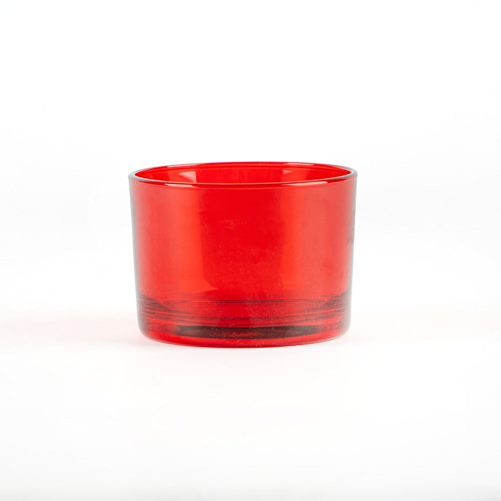 Bicchiere di vetro rosso trasparente, cilindrico, con fondo spesso, su sfondo bianco.