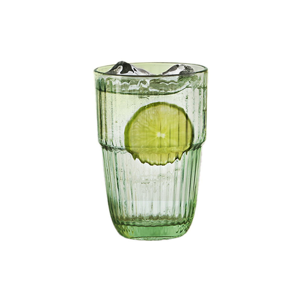 Bicchiere verde trasparente con superficie rigata contenente acqua, due cubetti di ghiaccio e una fetta di