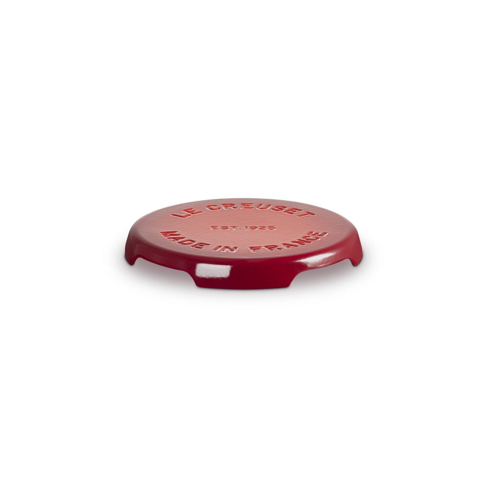 Coperchio rotondo rosso lucido con scritte in rilievo "LE CREUSET" e "MADE IN FRANCE", su sfondo bianco.