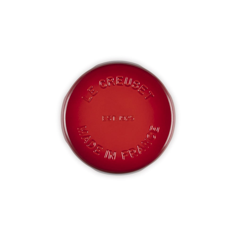 Tegame rotondo di colore rosso, in ghisa smaltata, con scritte "LE CREUSET" e "MADE IN FRANCE" in rilievo. Fondo liscio.