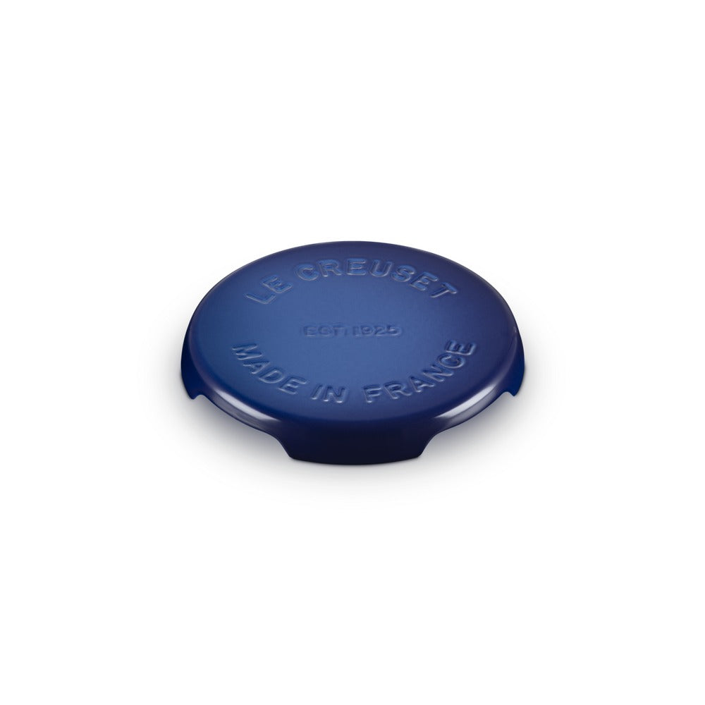 Coperchio rotondo di colore blu, in ceramica smaltata, con inciso "LE CREUSET MADE IN FRANCE" sulla superficie.