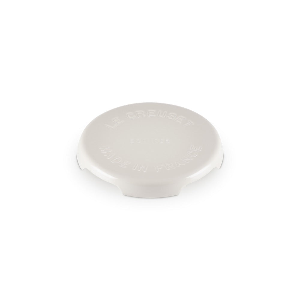 Tappo rotondo in ceramica bianca con incisi "LE CREUSET" e "MADE IN FRANCE", superficie liscia e leggermente lucida.
