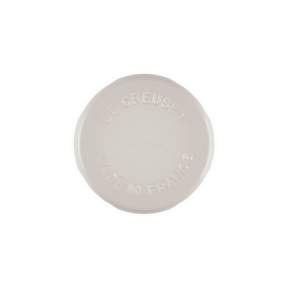 Piatto rotondo in ceramica di colore bianco, con impresso il logo "LE CREUSET" e la scritta "MADE IN FRANCE".