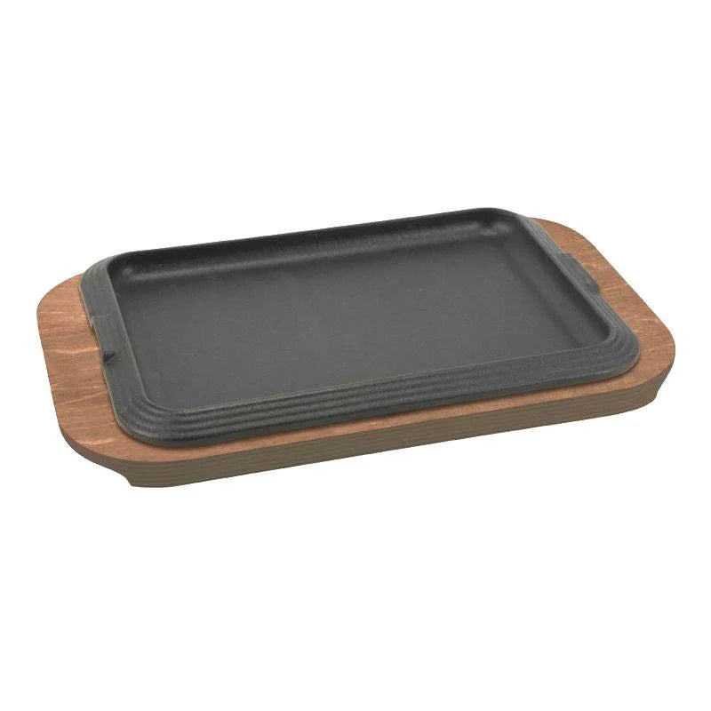 Plancha rectangular negra de metal sobre base de madera marrón claro con esquinas redondeadas, sin fondo visible.