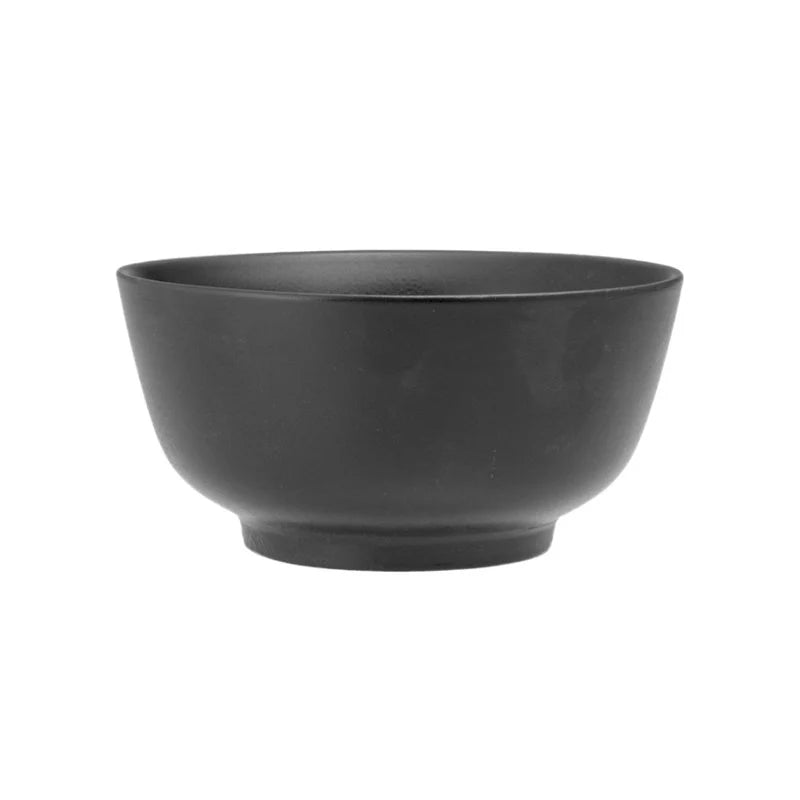 Cuenco de color negro, forma redonda con base ligeramente elevada, materiales no especificados, fondo blanco neutro.