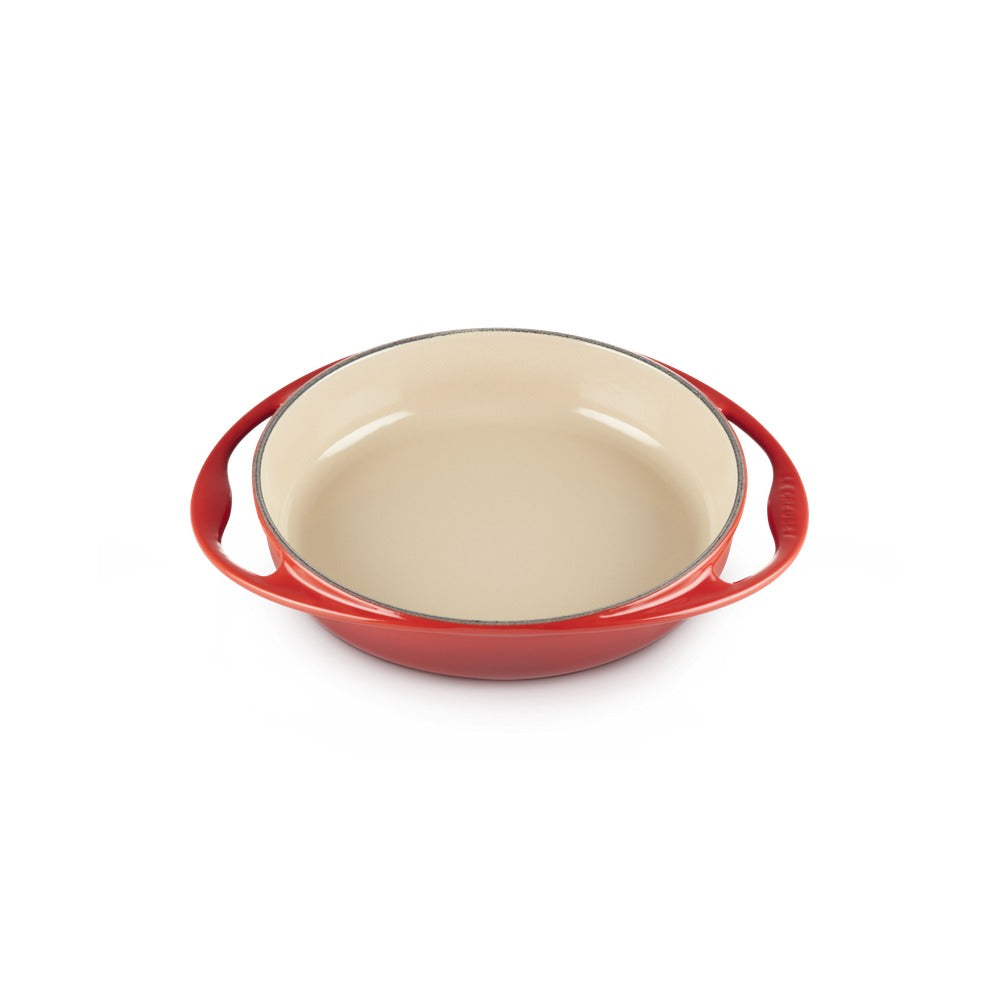 Pirofila rotonda con manici, esterno rosso e interno beige, in materiale ceramico smaltato.