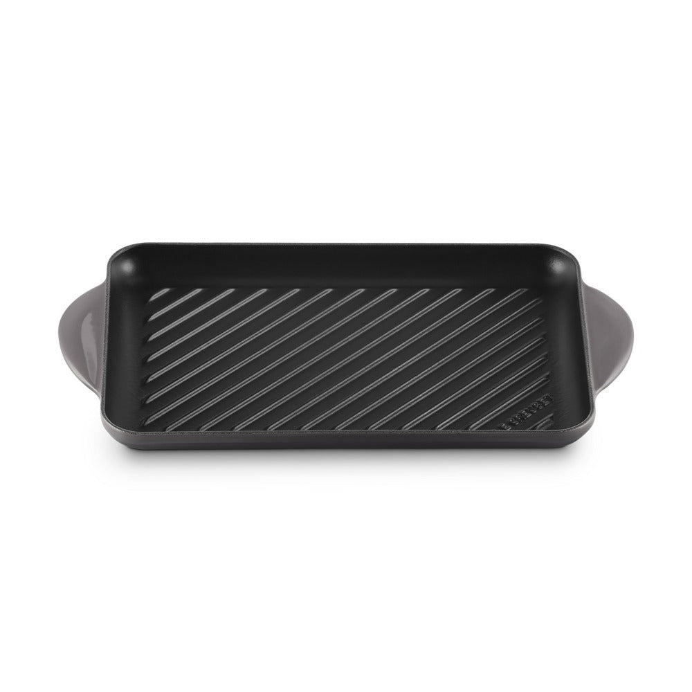 Teglia rettangolare in metallo nero con superficie rigata e manici curvi. superficie opaca e semplice.