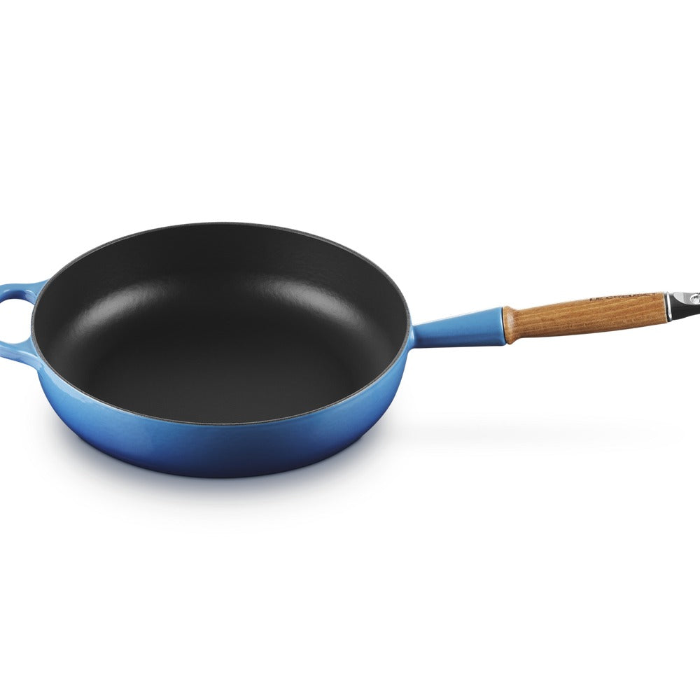 Padella rotonda blu con manico in legno, superficie interna nera e finitura liscia. Fondo piatto e bordi arrotondati.
