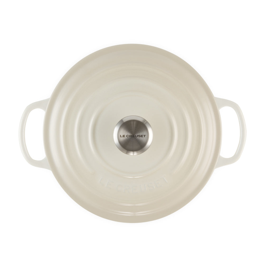 Coperchio tondo smaltato beige chiaro con doppia maniglia, pomolo in acciaio con scritta Le Creuset, su sfondo bianco.