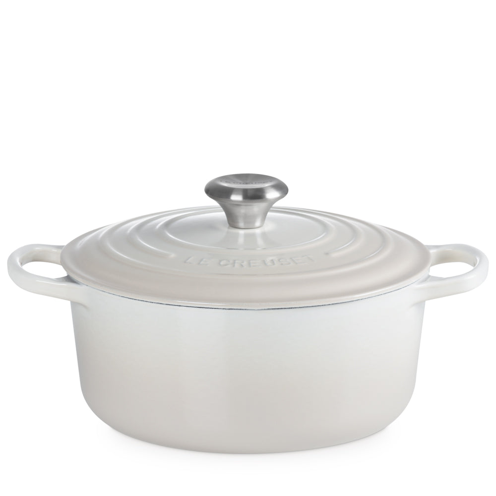 Casseruola bianca in ghisa smaltata con coperchio e manico in acciaio, doppia maniglia laterale, marchio Le Creuset inciso sul coperchio.