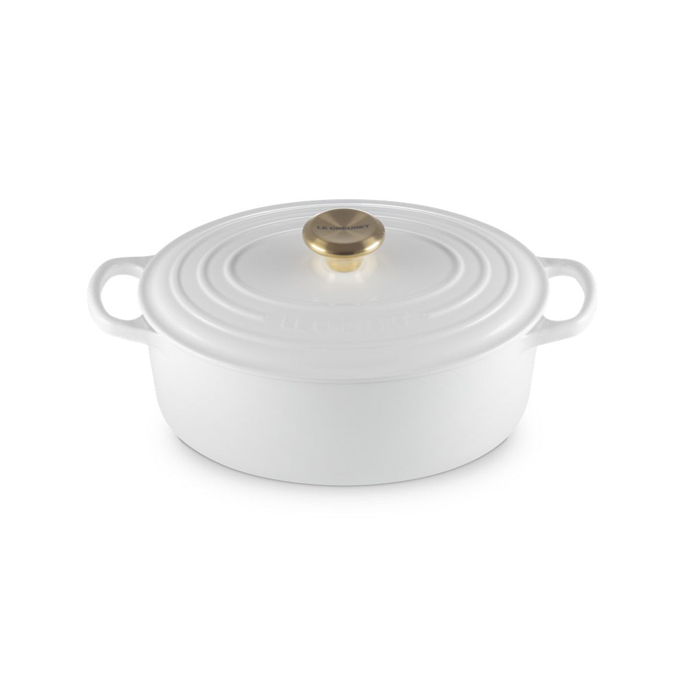 Casserole blanche en céramique avec couvercle, anses latérales et pomme dorée centrale.