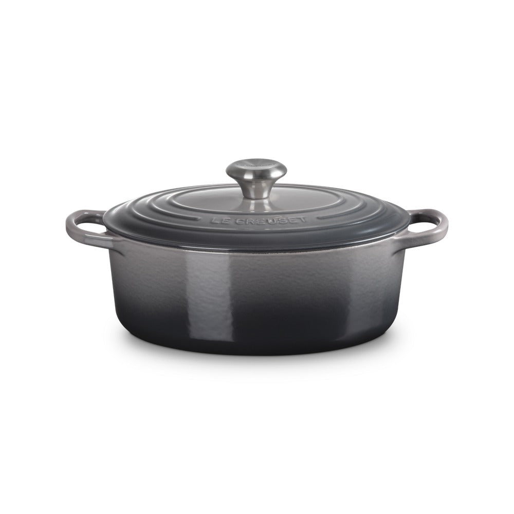 Casserole ovale en fonte émaillée grise avec couvercle, anses latérales et bouton centrale.
