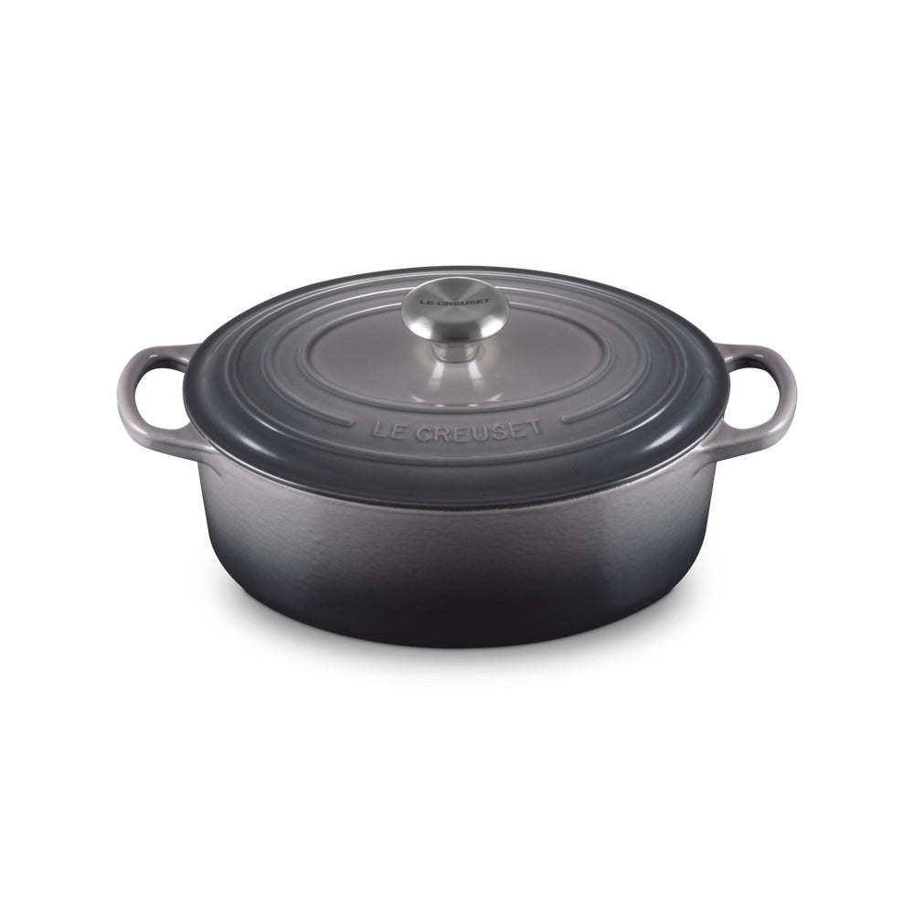 Cocotte en fonte émaillée grise, avec couvercle et poignée en acier, posée sur une surface claire.
