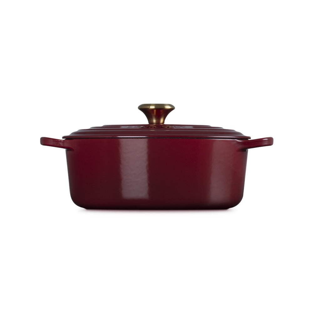 Casserole carrée rouge avec anses et couvercle, en fonte émaillée, poignée dorée brillante.