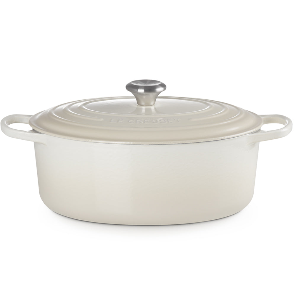 Witte ovale geëmailleerde pan met bijpassend deksel en geïntegreerde handgrepen, glanzende metalen knop, keuken.