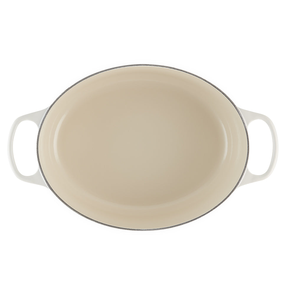 Beige ovale keramische koekenpan met witte handgrepen op witte achtergrond