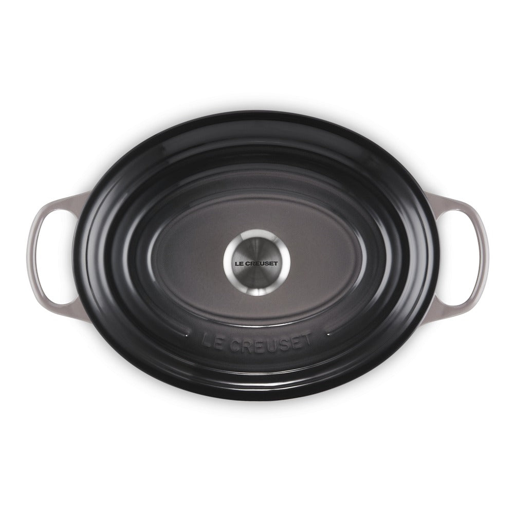Zwart geëmailleerd ovaal gietijzeren bord met handgrepen, glad oppervlak en zilveren centrum, met gravure "LE CREUSET".