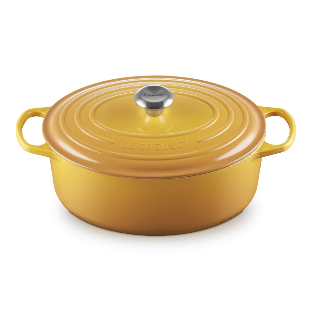 Geëmailleerde braadpan geel met deksel, handgrepen inclusief en dekselknop van staal, disegno golvend sulla oppervlak.
