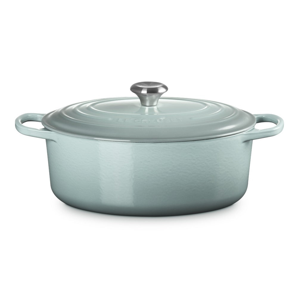 ovaal braadpan van keramiek lichtgroen, met deksel, zijhandgrepen en dekselknop metalen. bodem piatto en glad oppervlak.