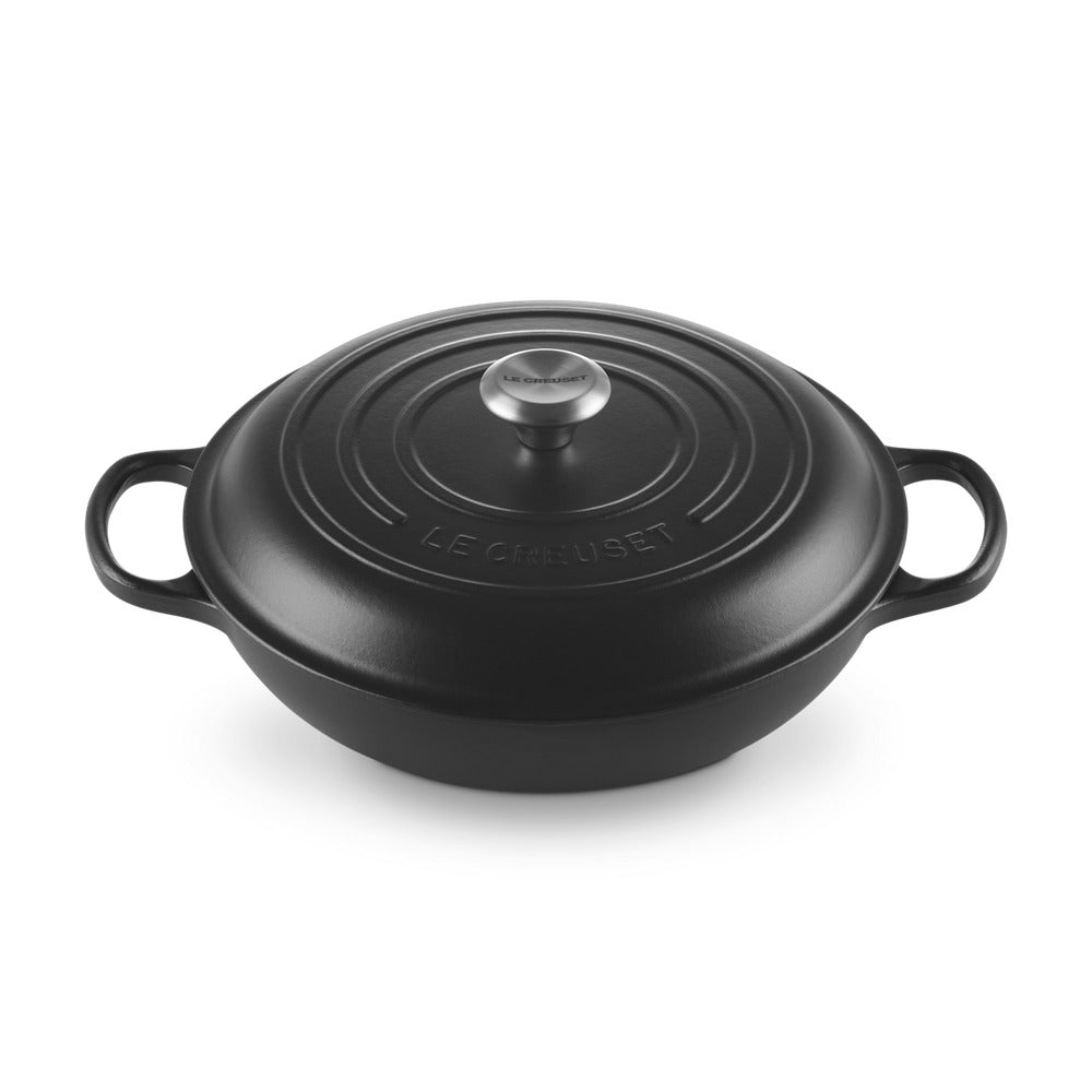 Casseruola in ghisa smaltata di colore nero, con coperchio e manici laterali, superficie liscia e lucida, elegante e moderna.