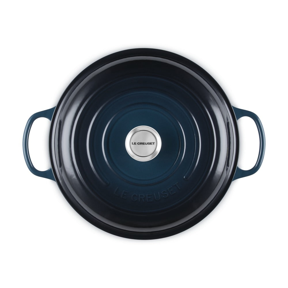 Casseruola rotonda in ceramica blu scuro con manici, logo centrale "LE CREUSET" e superficie liscia.