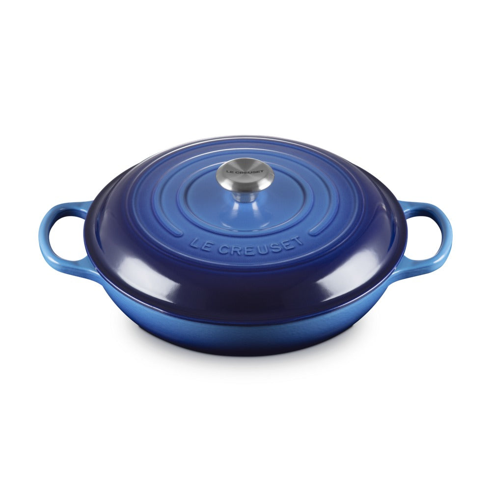 Casseruola blu in ghisa con coperchio, manici laterali e pomolo centrale in acciaio. Marca visibile: LE CREUSET.