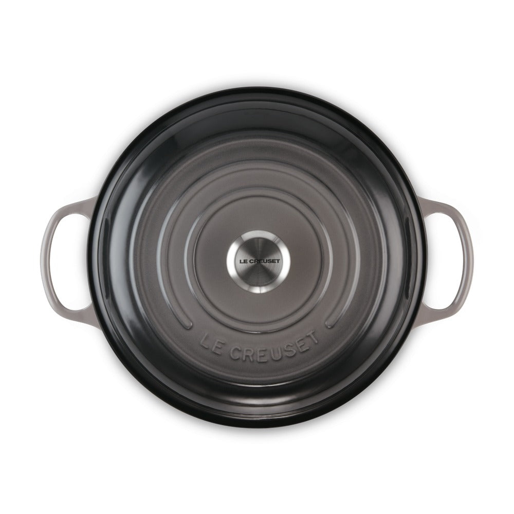 Pentola rotonda in ghisa smaltata di colore grigio scuro con manici laterali e logo "LE CREUSET" al centro.