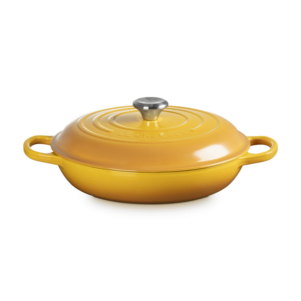 Casseruola rotonda gialla in ghisa con coperchio e manici laterali. Dettaglio lucido sul pomello in acciaio inox.
