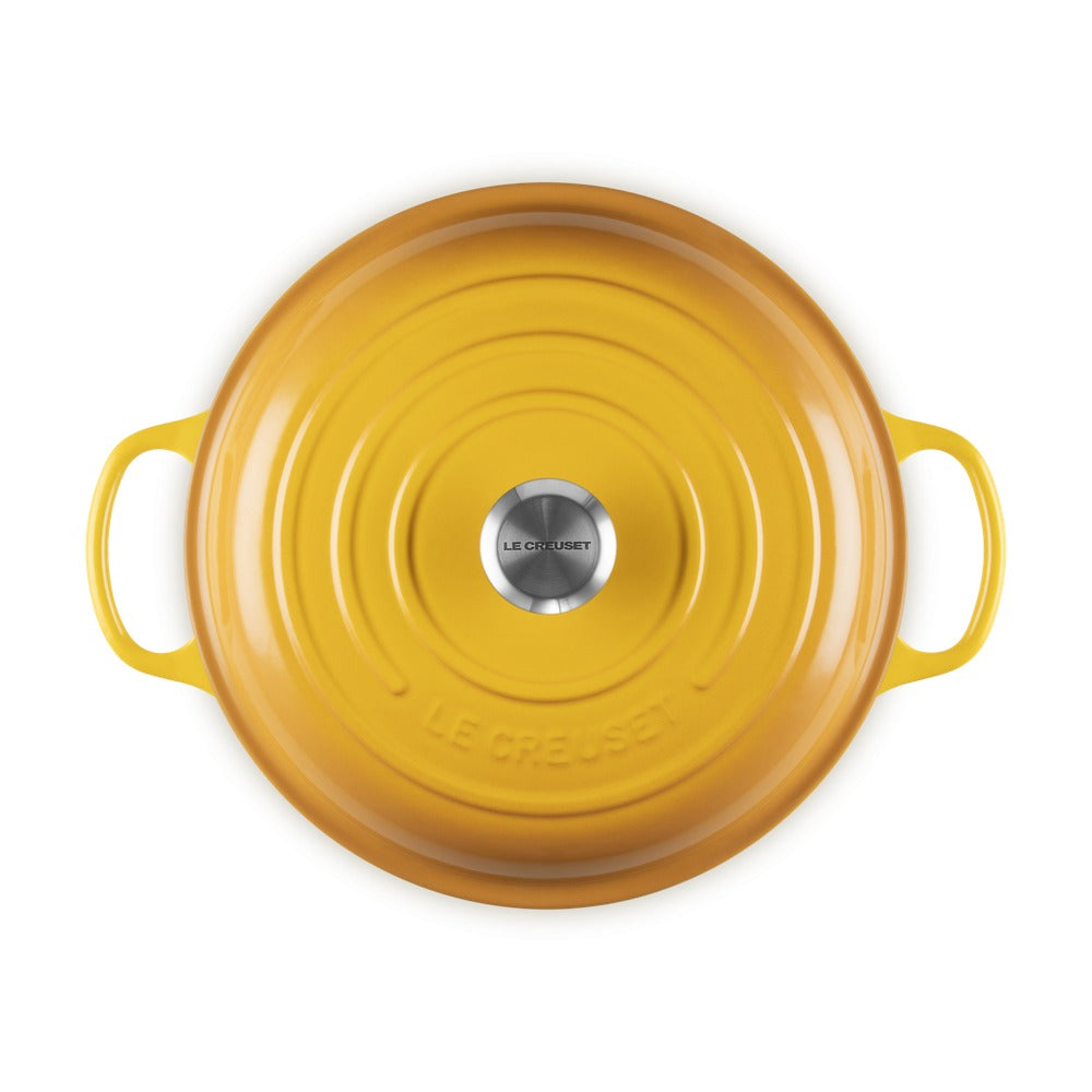Casseruola rotonda gialla con manici, superficie liscia e riflettente, con logo "LE CREUSET" al centro.
