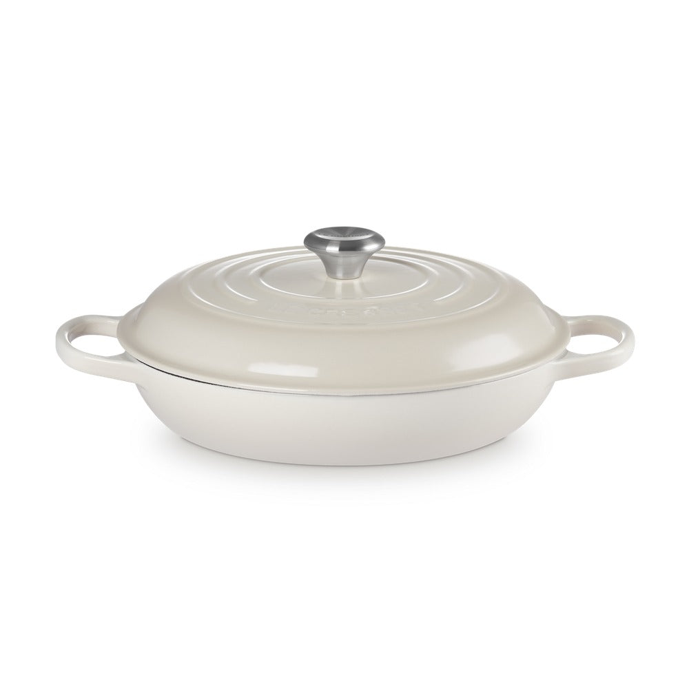 Casseruola ovale in ceramica bianca con coperchio e maniglie laterali, dotata di pomello in acciaio inox.