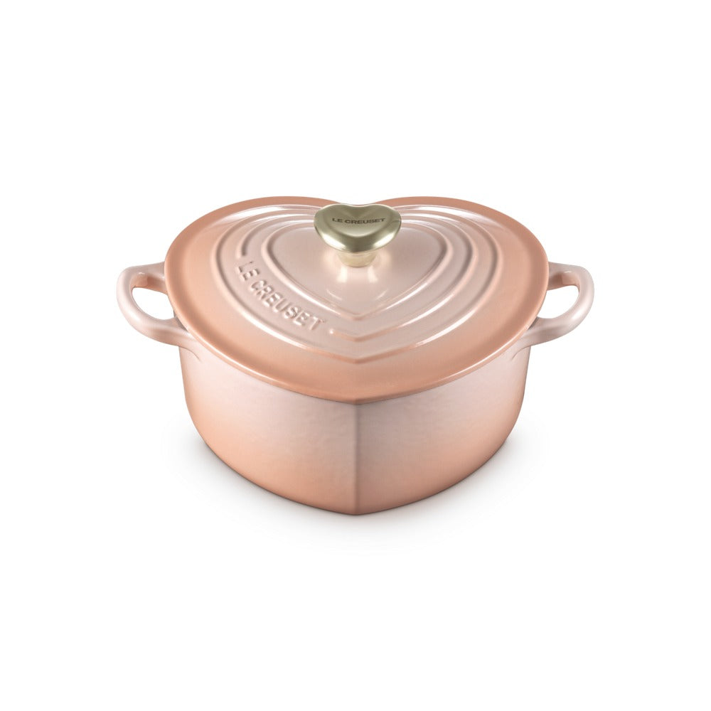 Cacerola en forma de corazón, color rosa, con asas laterales y tapa decorada. Decoración en relieve "LE CREUSET".