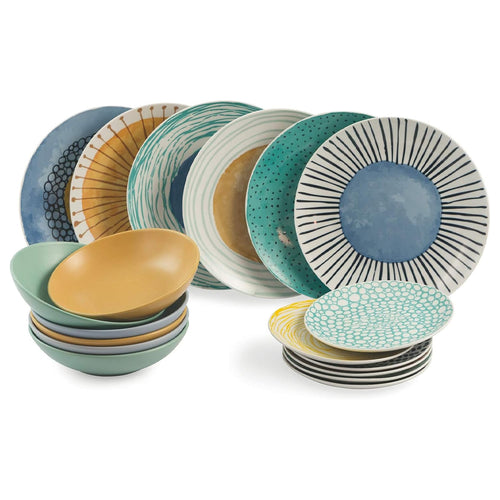 Set di piatti e ciotole in ceramica, con decorazioni variopinte: blu, verde, giallo, strisce e punti. Disposti in modo ordinato.