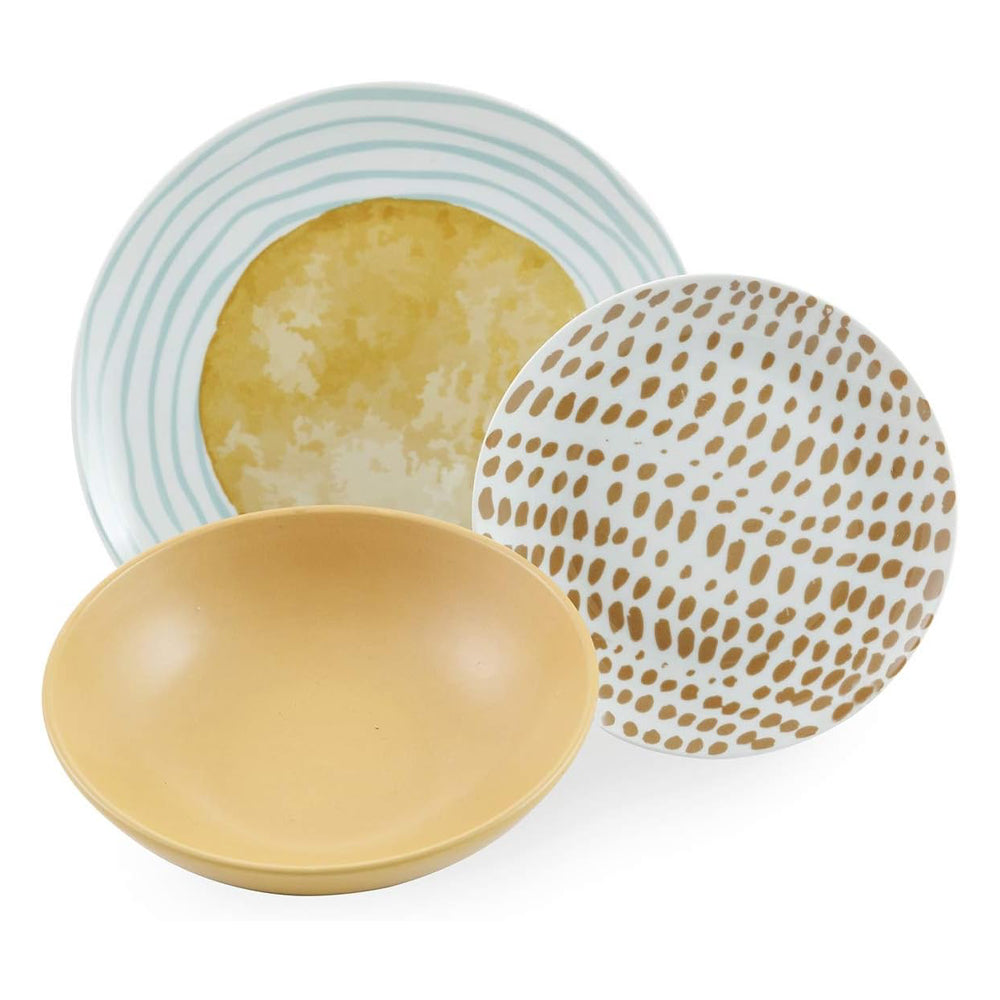 Trois assiettes empilées : une jaune, une à rayures bleu clair et une blanche avec taches dorées.