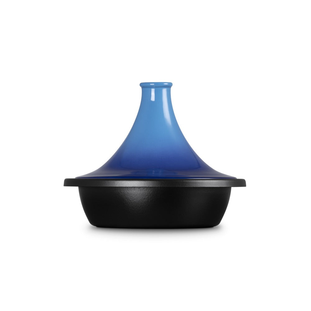 Tajine con coperchio blu sfumato sopra una base nera, forma conica e materiale ceramico. Fondo leggermente opaco, evidente contrasto di colori.