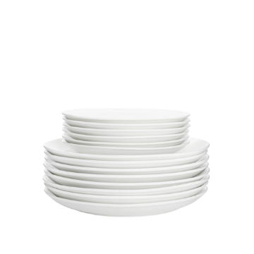 Stack di piatti bianchi in ceramica di diverse dimensioni su sfondo bianco.