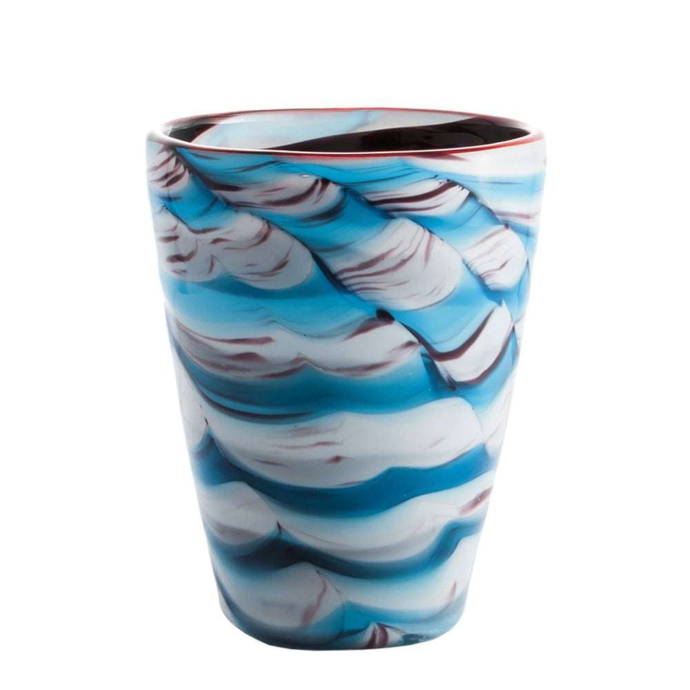Bicchiere in vetro blu, bianco e rosso con decoro a onde, forma cilindrica rastremata, sfondo bianco.