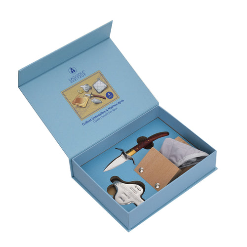 Set di attrezzi per molluschi in una scatola blu, con un coltello, un guanto e una placca in legno.