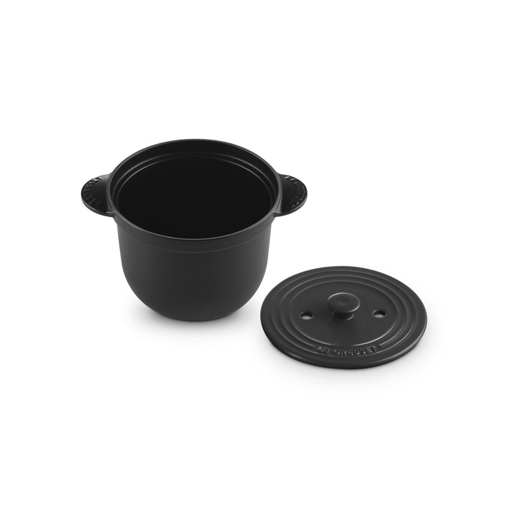 Cocotte ronde noire en fonte avec couvercle, avec anses latérales et surface lisse.