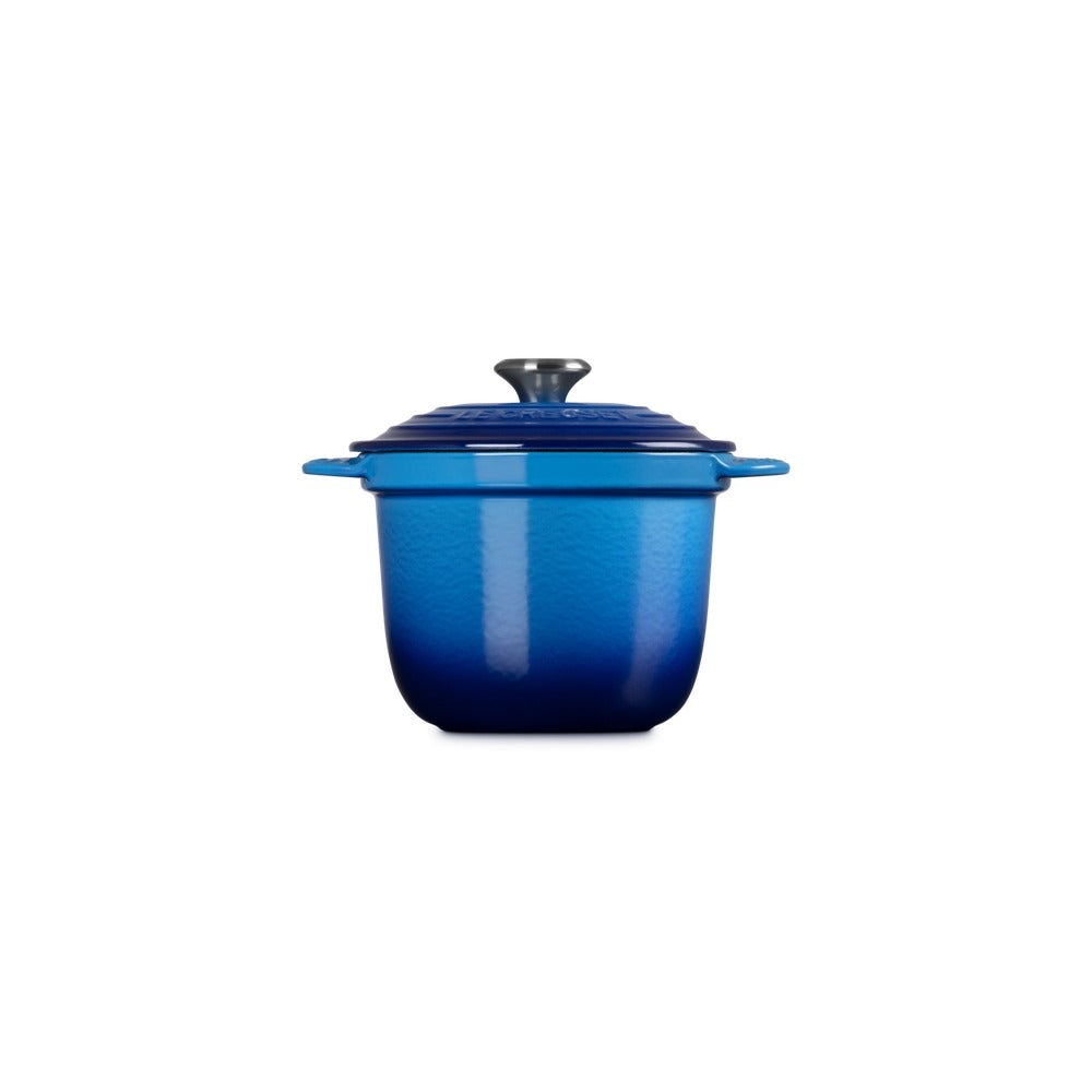Cocotte en fonte émaillée bleu dégradé, avec couvercle et poignée, surface brillante et détails en métal.