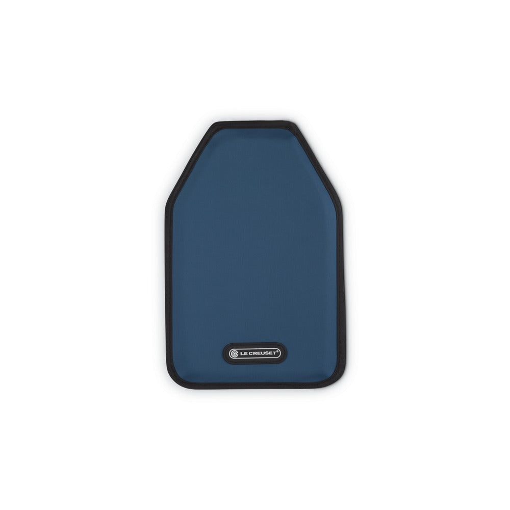 Soggetto principale blu opaco con bordo nero, forma asimmetrica, superficie liscia; visibile logo "LE CREUSET".