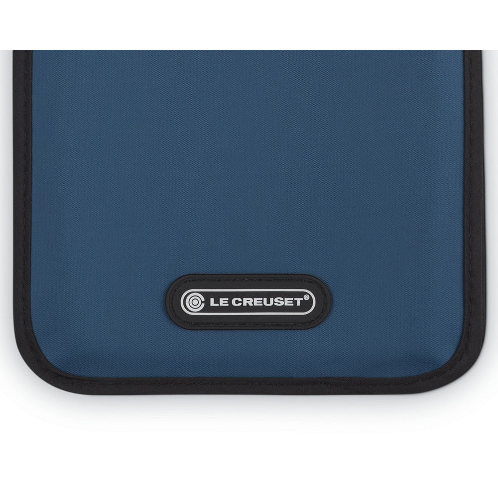 Sacco termico blu con bordo nero, dotato di logo "LE CREUSET" in bianco e nero, fondo uniforme e forma rettangolare.