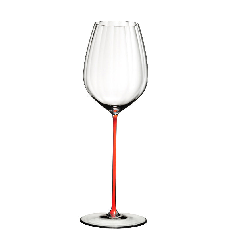 Calice da vino in vetro trasparente con stelo sottile e di colore rosso, sfondo bianco.