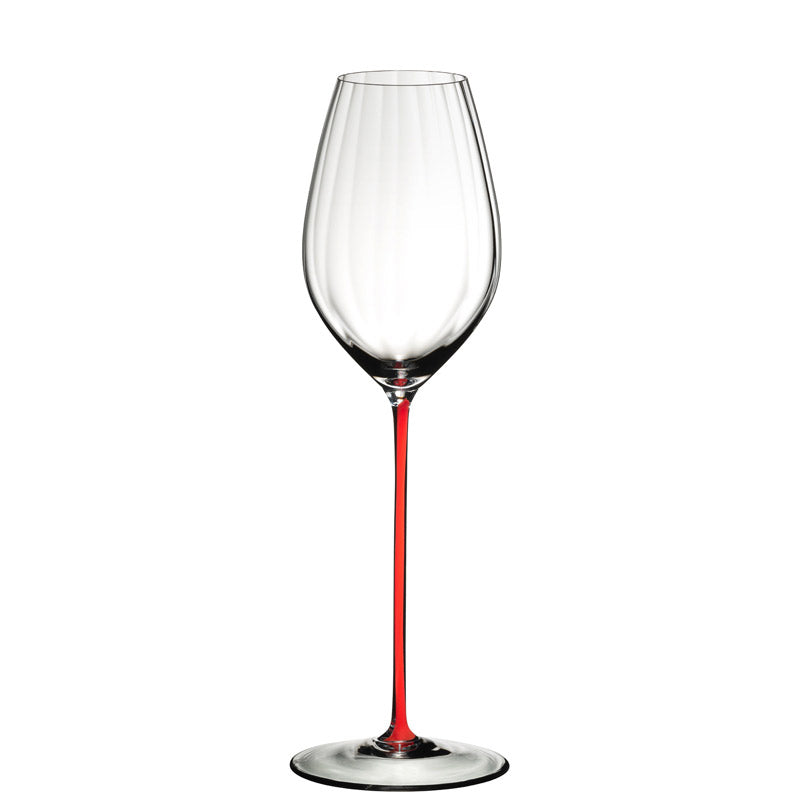 Copa de vino con pie fino rojo y copa transparente de vidrio, sobre fondo blanco.