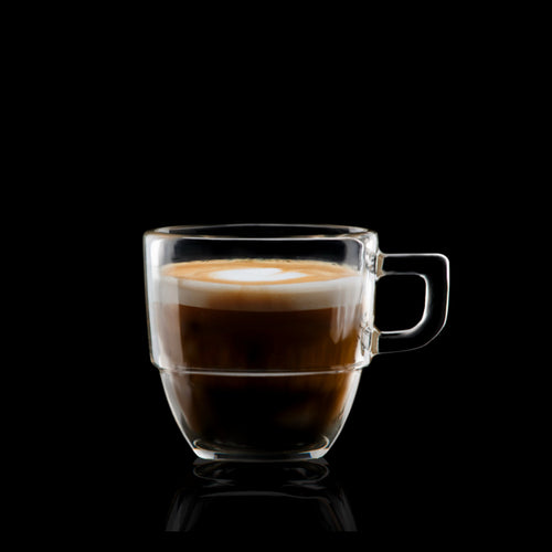 Tazza di caffè in vetro trasparente, con strati di crema e caffè scuro, su sfondo nero.