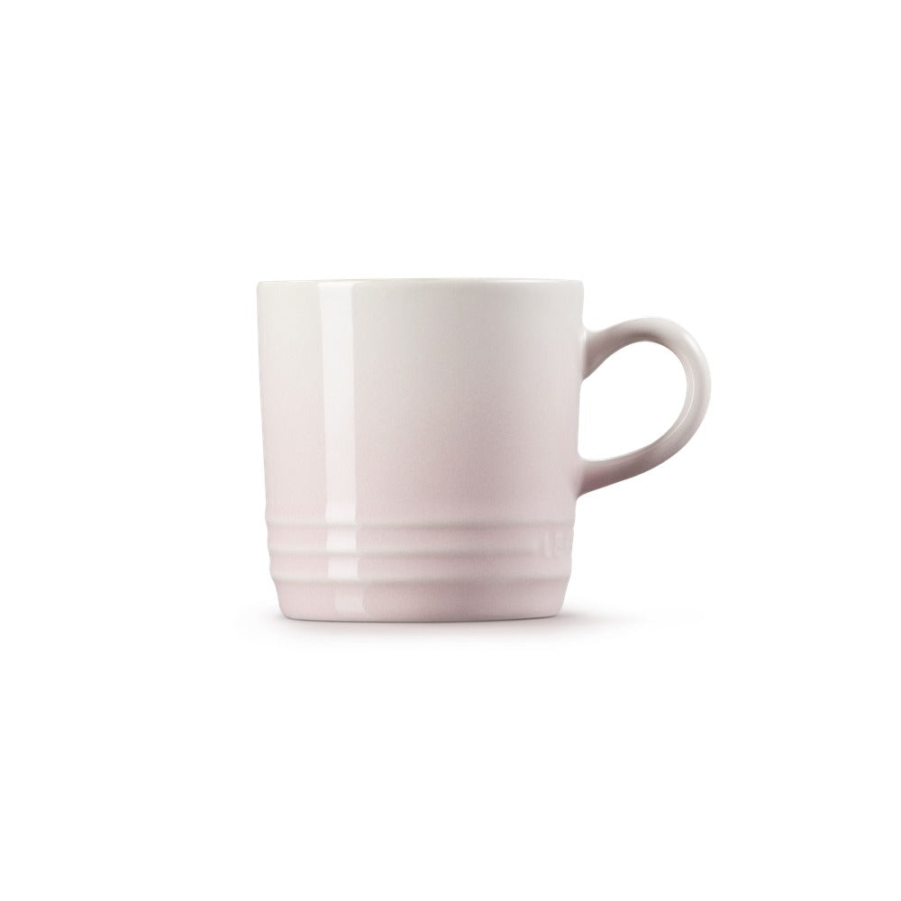 Tazza in ceramica, colore rosa chiaro con manico, superficie liscia e decorazione a righe sul fondo.