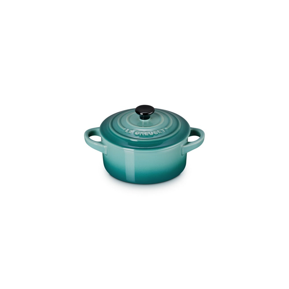 Casseruola ovale in ceramica di colore turchese, con coperchio nero e maniglie laterali. Presenta un effetto sfumato.
