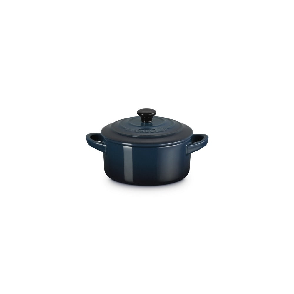 Casseruola rotonda in ceramica blu scuro con coperchio e manici, su sfondo bianco.