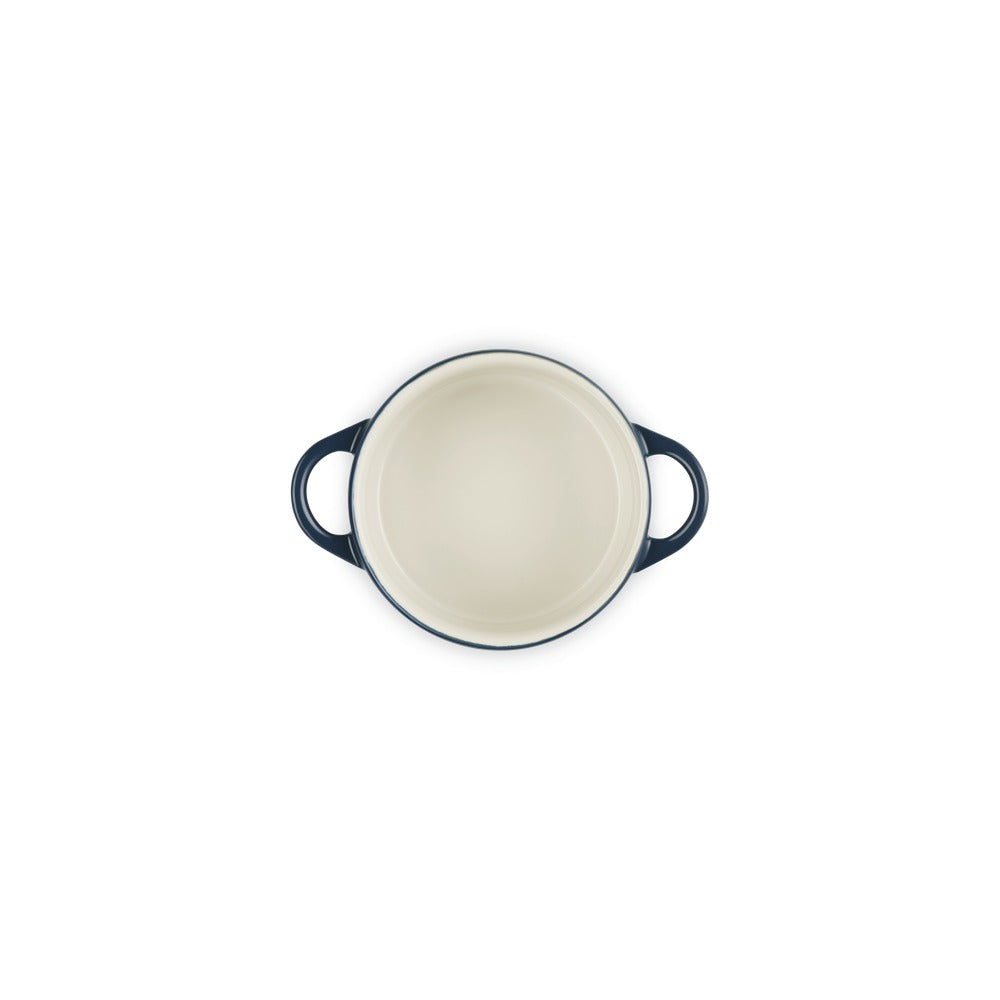 Casseruola rotonda con manici, interna chiara e finitura esterna blu scuro, su sfondo bianco.