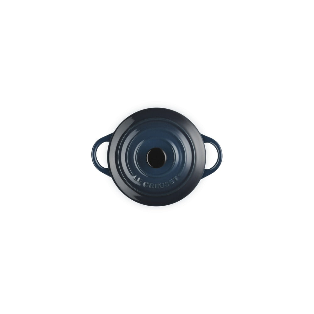 Casseruola in ceramica smaltata blu scuro con due maniglie e foro centrale. Superficie lucida e logo "Le Creuset" visibile.