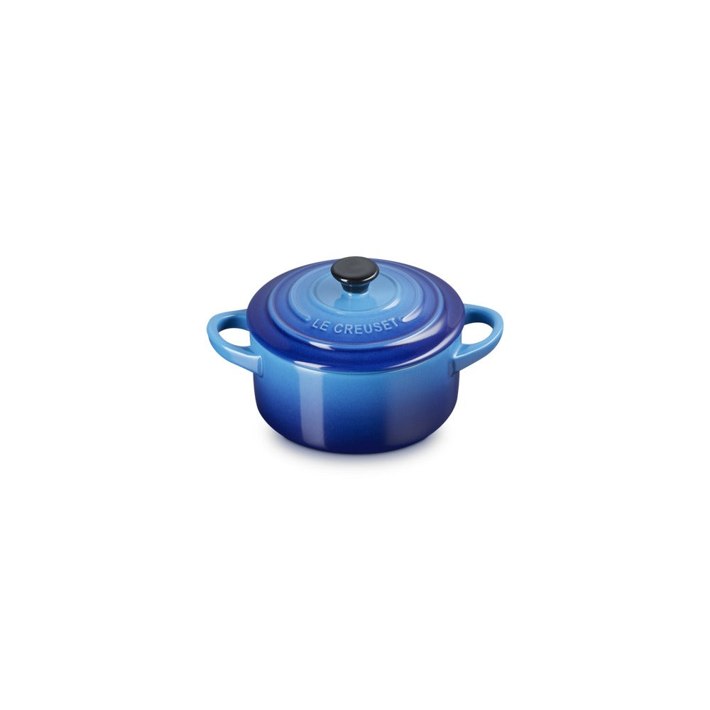 Casseruola di ceramica smaltata blu con coperchio e manici, lucida e arrotondata, su sfondo bianco.